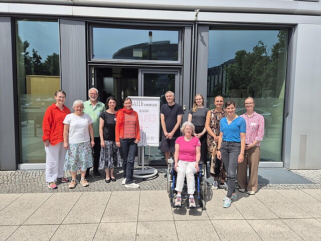 SAMS-Pat Workshop 01.07.2026 Die Mitglieder des SAMS-Pat Beirats und das SAMS-Pat Team stehen gemeinsam vor der Glaswand des Veranstaltungsortes