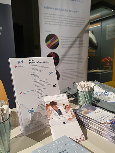 Infostand im Naturkundemuseum des German Stem Cell Network und Netzwerkbüro für Gene and Cell Therapies mit unterschiedlichen Materialien
